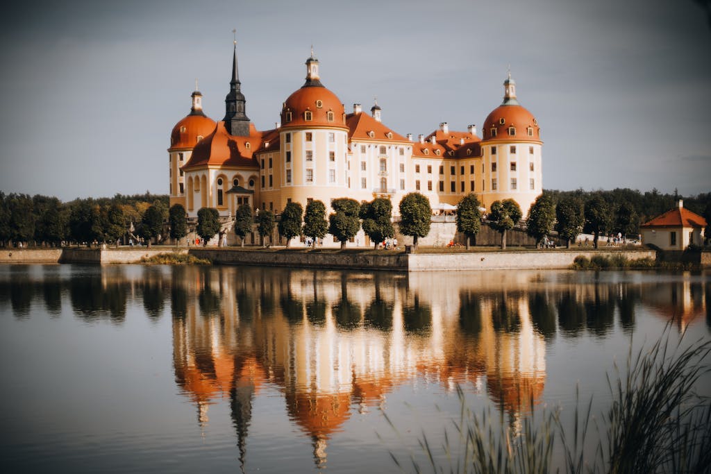 Scenic view of Moritzburg Castle reflected in the lake under a serene sky.