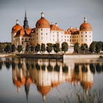 Scenic view of Moritzburg Castle reflected in the lake under a serene sky.
